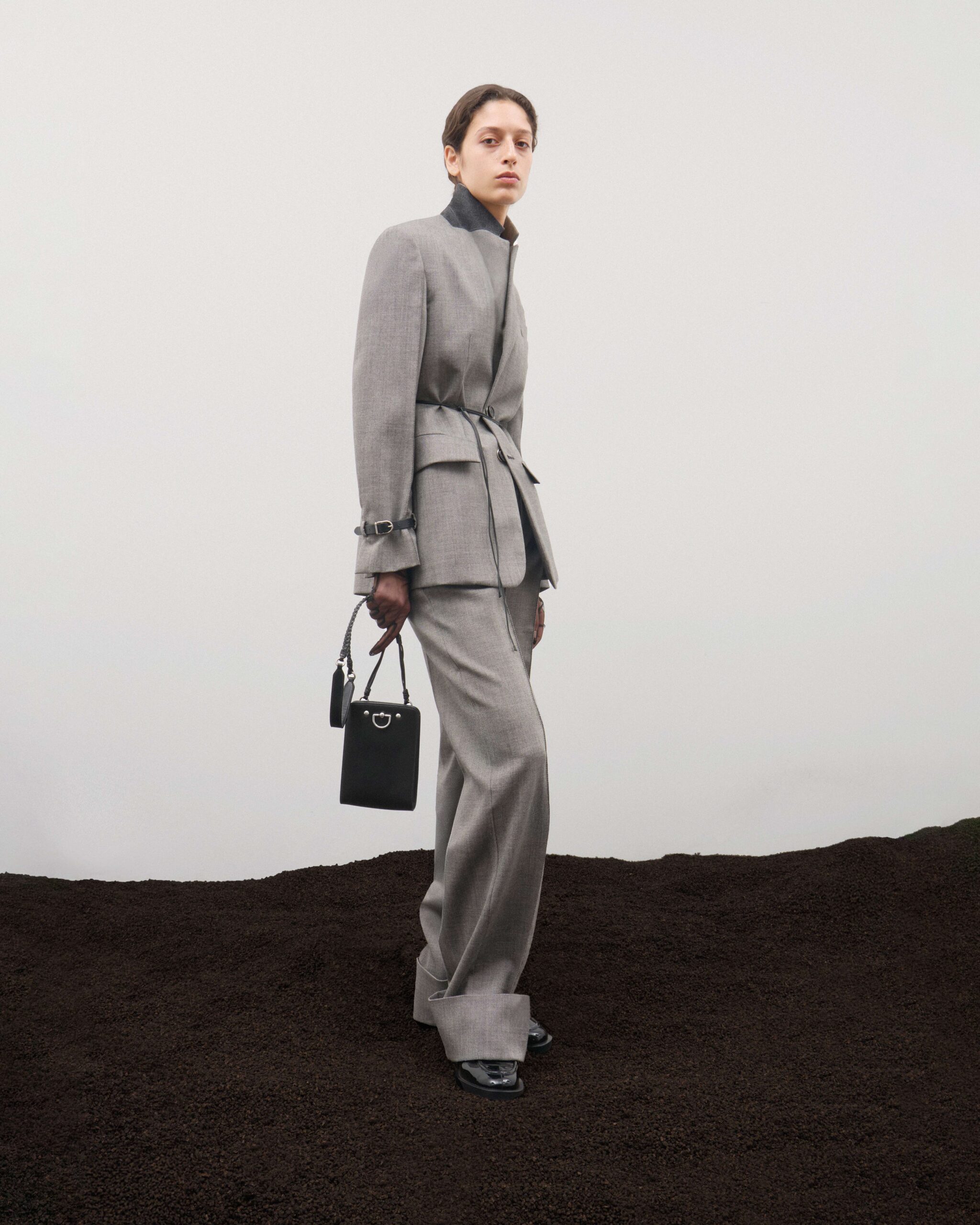 Light grey tailored jacket with leather tie fastening, matching wide trousers and black leather Tile Bag, Durazzi Milano FW26